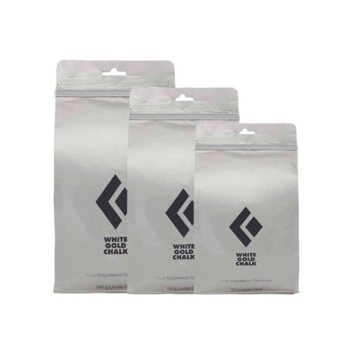 Tres bolsas plateadas con la etiqueta "Magnesio Black Diamond Loose Chalk" (magnesio para tizas sueltas Black Diamond) se encuentran una al lado de la otra, de distintos tamaños. Cada bolsa contiene carbonato de magnesio puro (conocido por su uso en escalada o gimnasia) y tiene un logotipo sencillo que recuerda a Black Diamond en el frente.