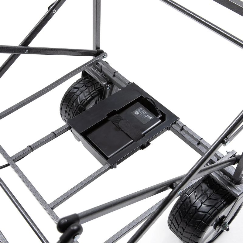 Vista en primer plano de un armazón de carrito plegable, similar al Carro de Transporte Eléctrico Kano Sherpa Turbo Plegable, que muestra neumáticos resistentes y una batería rectangular asegurada debajo. El armazón de metal tiene barras transversales para brindar soporte adicional, lo que garantiza que este modelo sea robusto y eficiente.