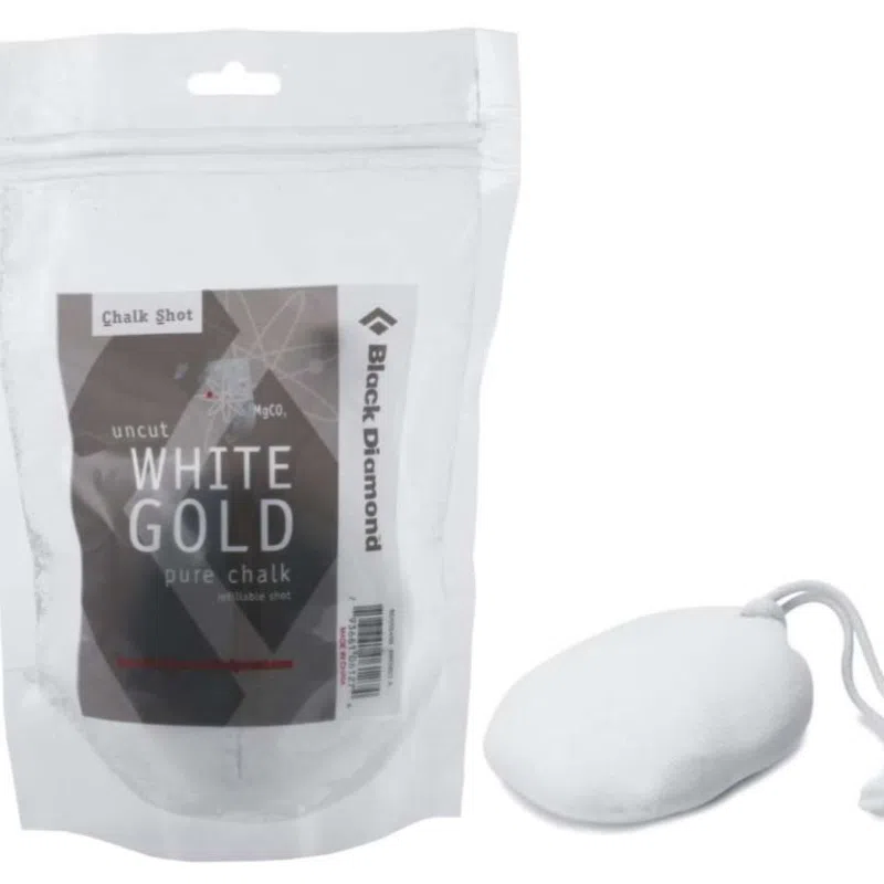 Un paquete de Magensio Black Diamond Recargable Chalk Shot 50, que incluye una bolsa resellable, se encuentra junto a una pelota Chalk Shot. El envase es transparente en la parte superior con una etiqueta blanca que muestra de forma destacada el nombre del producto.