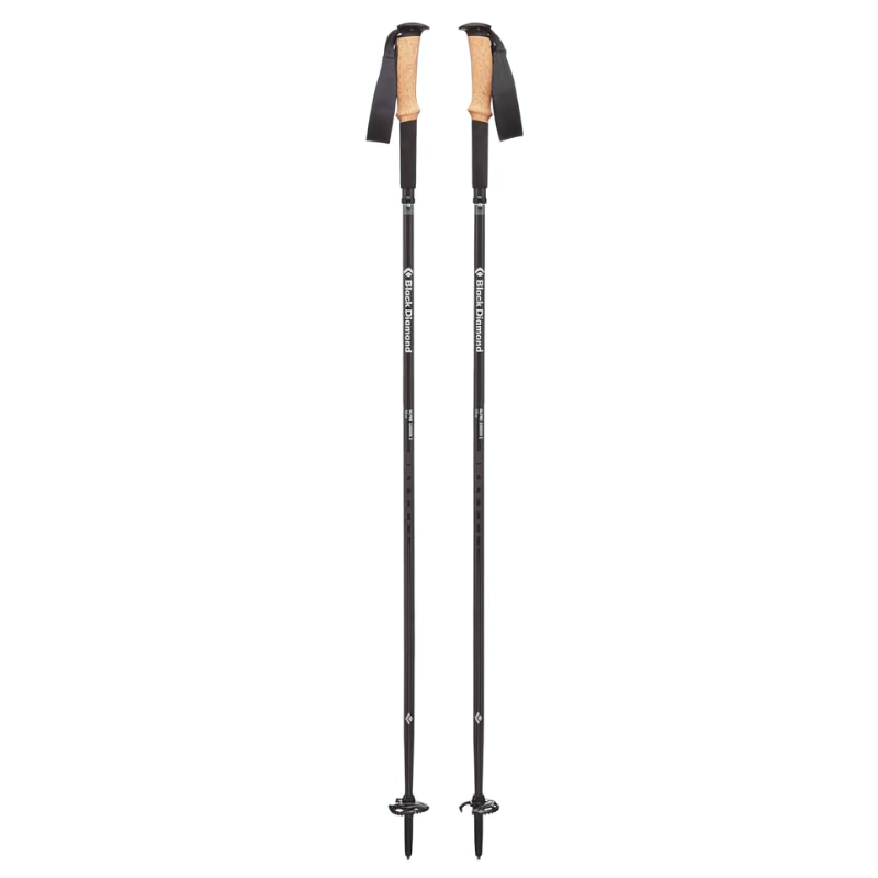 Un par de bastones de trekking negros con empuñaduras de corcho y correas para las muñecas. Los bastones tienen longitudes ajustables y puntas puntiagudas para mayor estabilidad en diversos terrenos.