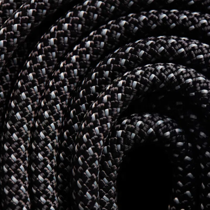 Primer plano de la cuerda trenzada en blanco y negro enrollada, que muestra los patrones intrincados y resalta la textura y las fibras entrelazadas de la Cuerda Estática Black Diamond 10.0 mm.