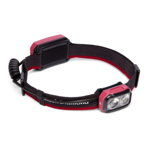 Presentamos la linterna frontal Black Diamond Onsight 375, una linterna frontal roja y negra con una unidad de luz rectangular que tiene dos lentes circulares. Cuenta con una correa elástica ajustable y una batería trasera, lo que la hace ideal para iluminación con manos libres durante diversas actividades.