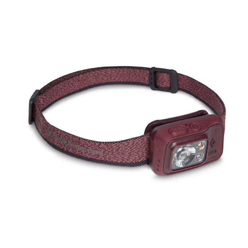 La linterna frontal Black Diamond Spot 400-R de color marrón tiene una correa ajustable y múltiples luces LED en un diseño delgado y rectangular. Es perfecta para actividades al aire libre o iluminación con manos libres.