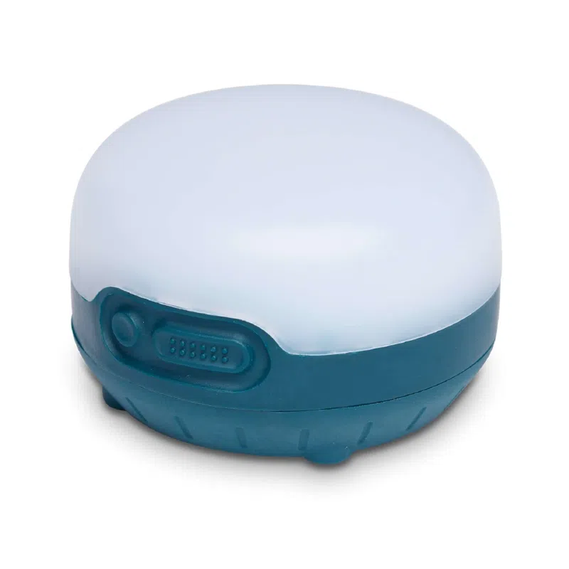 La linterna recargable Black Diamond Moji R+ es una linterna LED para acampar compacta y redonda con un cuerpo azul y una parte superior blanca. Tiene una base con textura y un pequeño botón en el lateral para un uso sencillo. Perfecta para actividades al aire libre o para uso en emergencias, esta linterna proporciona una iluminación confiable donde sea que la necesites.