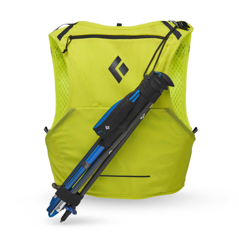 Esta mochila ligera de color amarillo óptico con un logotipo de diamante negro cuenta con un bolsillo frontal con cremallera y un bastón de trekking azul y negro sujeto en la parte posterior. Su diseño elegante cuenta con una textura similar a la de una malla, perfecta para los espíritus aventureros que valoran la forma y la función, como un chaleco de hidratación.