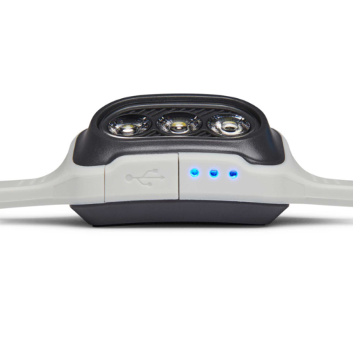 Primer plano de la elegante Linterna Frontal Black Diamond Deploy 325lm, que cuenta con tres luces circulares en la parte superior y emite una luminosidad de 325 lúmenes. El diseño se moderniza aún más con tres luces indicadoras azules y un símbolo USB en el lateral que sugiere opciones de conectividad versátiles.