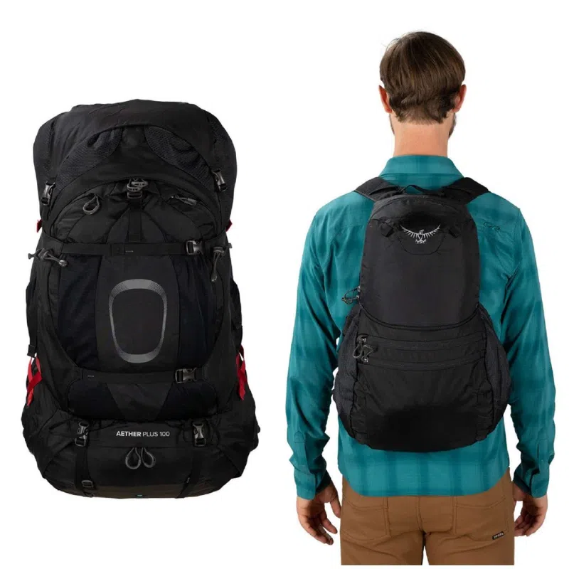 Un hombre lleva una camiseta verde azulado y unos pantalones marrones, complementados con una mochila negra. A su lado hay una mochila de senderismo negra más grande con la etiqueta "Mochila Osprey Aether Plus 85L". Ambas mochilas tienen varias correas, lo que indica que son adecuadas para aventuras al aire libre.