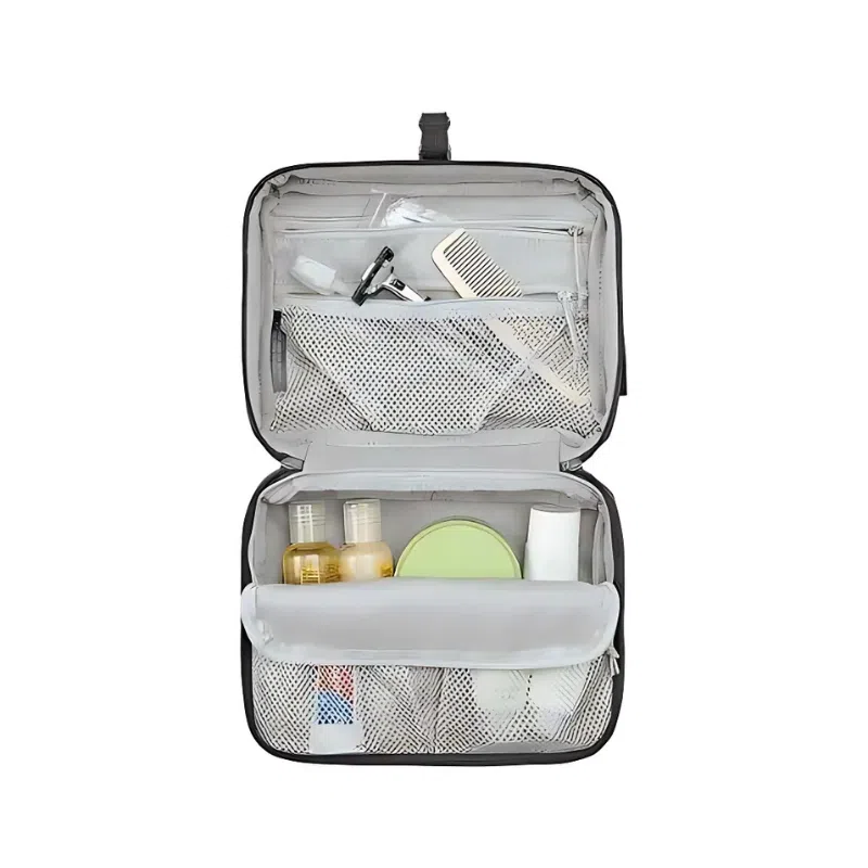 Abre el organizador de viaje Osprey Daylite Hanging Toiletry Kit para descubrir bolsillos de malla que contienen botellas pequeñas, un peine, una maquinilla de afeitar y artículos de cuidado personal. Este bolso gris de Osprey incluye un práctico gancho para colgarlo.