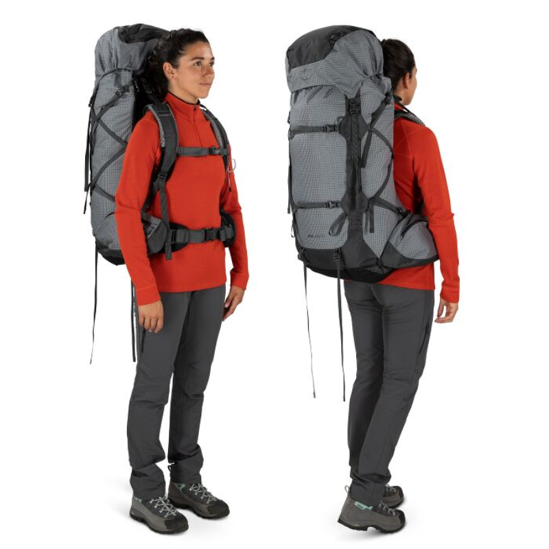 Una persona que viste una camiseta roja de manga larga, pantalones oscuros y botas de montaña lleva la Mochila Osprey Ariel Pro 75 Mujer. La imagen muestra vistas frontal y posterior, resaltando la gran mochila gris con correas negras.