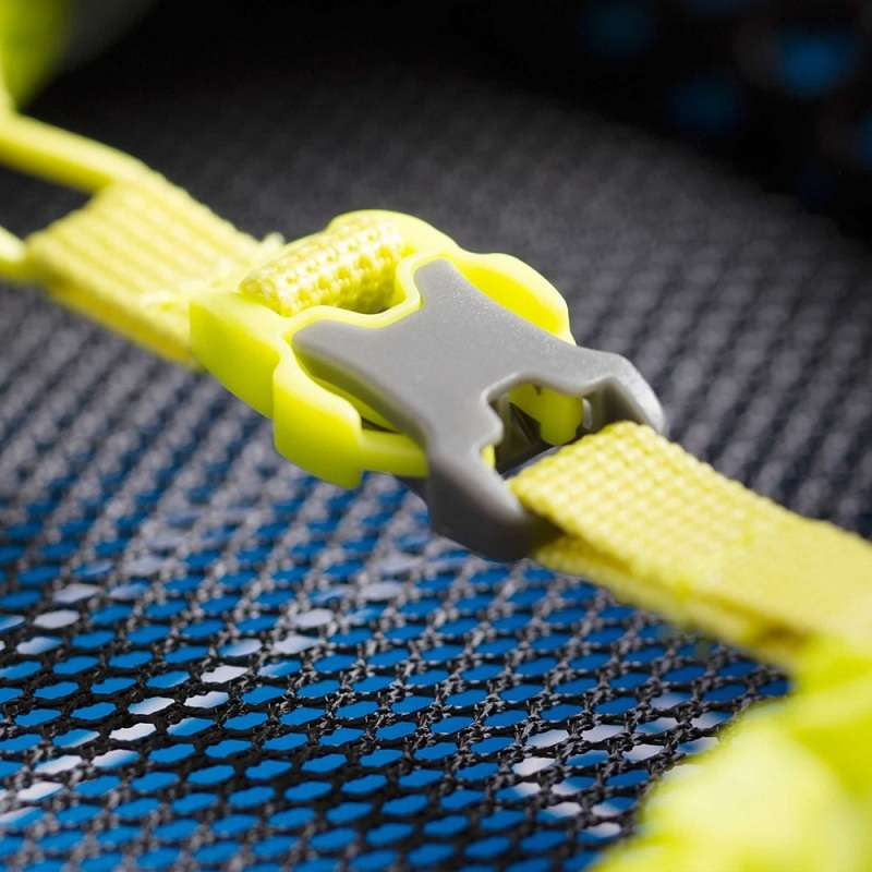 Una vista detallada muestra una hebilla de plástico amarilla y gris sujeta de forma segura a una correa amarilla vibrante, hábilmente diseñada para la Funda Impermeable Osprey Ultralight Raincover, con un llamativo fondo de tela de malla azul y negra.