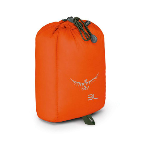 La Bolsa Osprey UL Stuff Sack 3 es una mochila naranja con cierre de cordón que presenta un logotipo y la palabra "3L" impresa. Incluye una presilla verde en la parte inferior y cordones oscuros con un ajustador de plástico, similar al diseño de la UL Stuff Sack.
