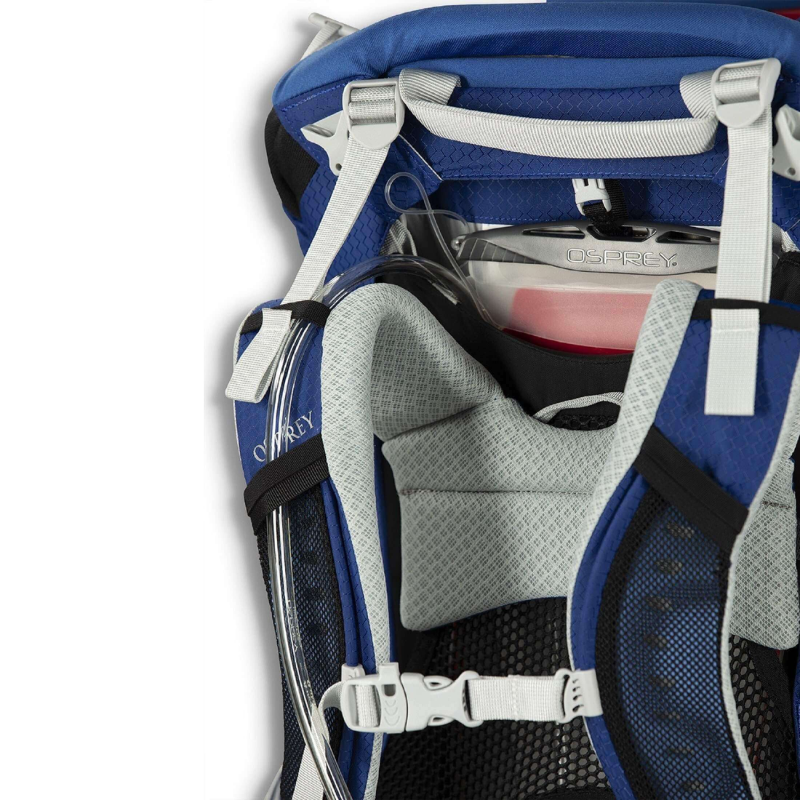 Primer plano de una mochila portabebé Osprey Poco Child Carrier, en la que se destacan sus correas acolchadas y su depósito de hidratación. La mochila portabebé es azul con hebillas blancas y cuenta con un acolchado de malla gris para una máxima comodidad.