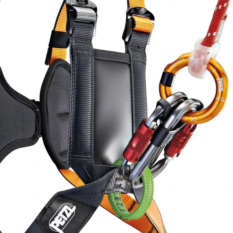 Primer plano del arnés de Escalada Infantil Petzl Simba, en color negro con detalles y logotipo en color naranja, que incorpora múltiples mosquetones plateados y naranjas con mecanismos de bloqueo en color rojo para una máxima seguridad.