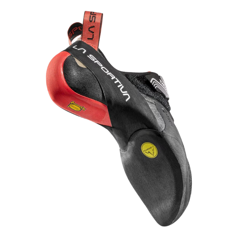 La zapatilla de escalada La Sportiva Theory (copia) es un pie de gato negro y rojo con un diseño curvo que muestra el logotipo de La Sportiva. Cuenta con detalles en amarillo y rojo en el talón y la suela, y está rematada con goma texturizada para un agarre superior.