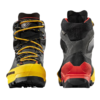 Un par resistente de botas de montaña Bota de Montaña La Sportiva Aequilibrium LT GTX negras y amarillas con suelas rojas; una muestra un patrón de cordones detallado, la otra resalta el diseño del talón y la banda de rodadura, mostrando un soporte de tobillo alto.