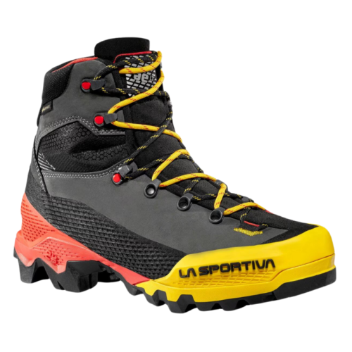 La bota de montaña La Sportiva Aequilibrium LT GTX es una bota de senderismo en negro y gris, con detalles en amarillo y rojo, que presenta cordones amarillos llamativos y una suela resistente. La marca "La Sportiva" se destaca de forma destacada en la sección amarilla de la puntera.