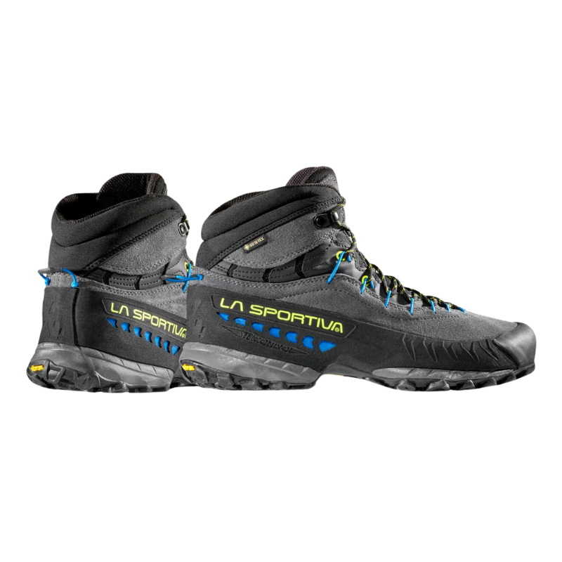 Las botas La Sportiva TX4 Mid GTX, en negro y gris con detalles en azul y amarillo, presentan un diseño de tobillo alto y suelas resistentes, ideales para aventuras al aire libre.