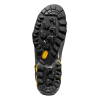 La imagen muestra la suela de una bota de senderismo negra similar a la Zapatilla de Aproximación La Sportiva TX5 GTX, que presenta una banda de rodadura resistente con ranuras profundas para una mejor tracción. Los detalles en amarillo y el nombre de la marca en amarillo están grabados en relieve en la suela sobre un fondo blanco.