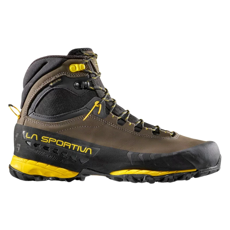 La bota de senderismo marrón y negra La Sportiva TX5 GTX presenta detalles amarillos, cordones, un logotipo "La Sportiva" en el lateral y una suela resistente perfecta para actividades al aire libre desafiantes.
