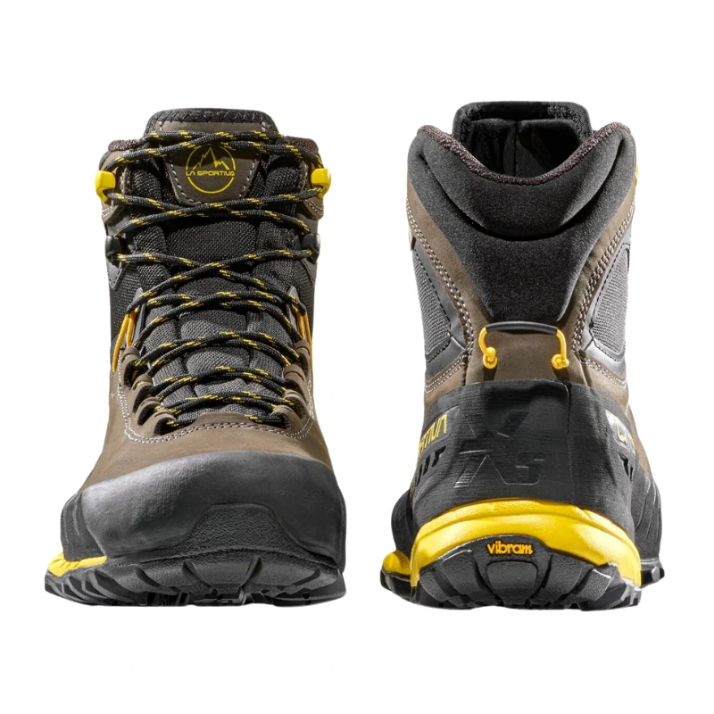 Un par de botas de senderismo marrones y amarillas con detalles en negro, similares a las La Sportiva TX5 GTX, presentan una vista frontal y posterior. El diseño incluye materiales duraderos, cordones intrincados, un cuello acolchado en el tobillo y una suela robusta ideal para actividades al aire libre.