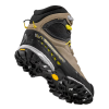 La Sportiva TX5 GTX Mujer es una bota de senderismo de caña alta en color marrón y negro con banda de rodadura resistente, detalles en amarillo y gris, ranuras de tracción profundas, marca visible y un práctico lazo de talón amarillo.