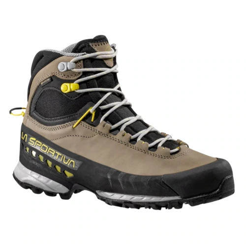 La bota de senderismo Zapatilla de Aproximación La Sportiva TX5 GTX Mujer presenta una banda de rodadura resistente y elegantes detalles en amarillo con cordones detallados, que ofrecen durabilidad y rendimiento, al tiempo que muestran el nombre de la marca en su exterior marrón y negro.