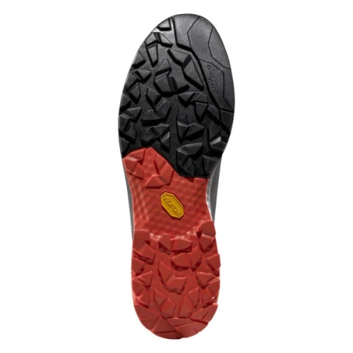 La zapatilla de aproximación La Sportiva TX Guide Leather presenta una suela resistente con un diseño de dos tonos en negro y rojo. Su dibujo irregular y texturizado, centrado por un logotipo amarillo, garantiza un agarre superior.