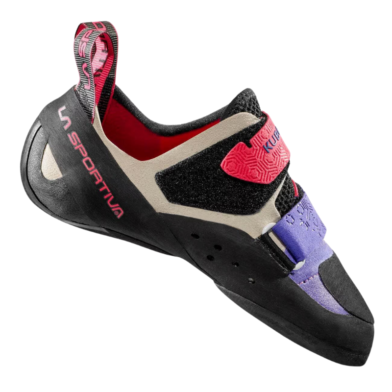 La zapatilla de escalada La Sportiva Kubo para mujer presenta una suela negra, un cuerpo beige y detalles en rosa. Incluye la marca "La Sportiva", correas de velcro y una presilla en el talón para facilitar su uso. Diseñada por expertos para el rendimiento en escalada.