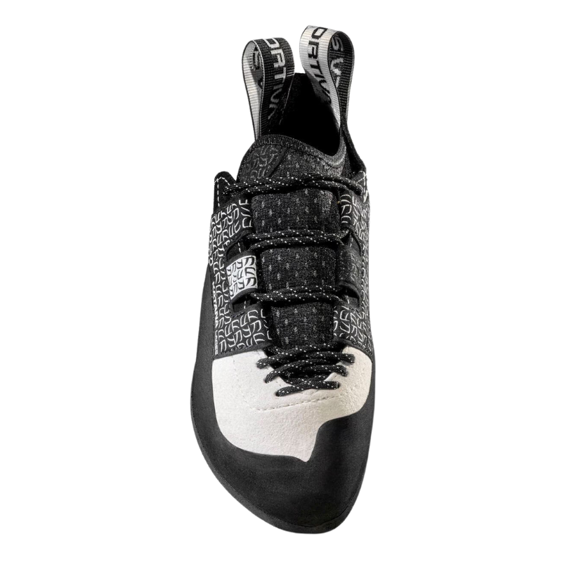 La zapatilla de escalada La Sportiva Katana Laces Mujer luce un patrón geométrico en blanco y negro, con tres correas de velcro, una puntera de goma prominente y una suela texturizada para un agarre óptimo durante las subidas.