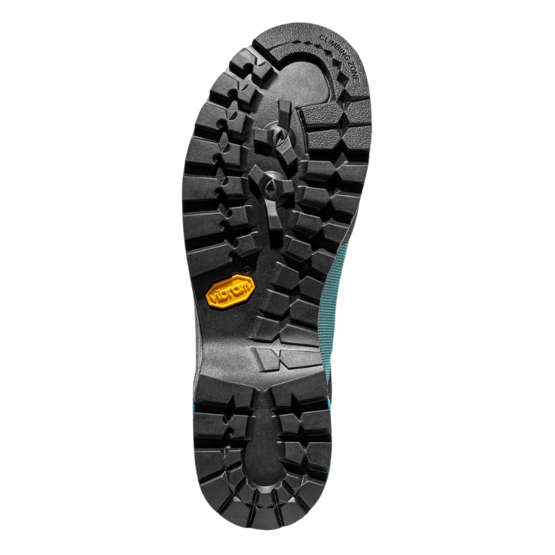 La imagen muestra la suela de una bota de trekking La Sportiva Trango Trk GTX Mujer, que presenta una banda de rodadura resistente y multidireccional para una tracción óptima. La suela es mayoritariamente negra con un logotipo amarillo cerca del talón.