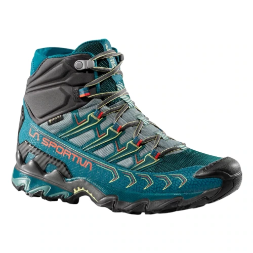 Explora la La Sportiva Ultra Raptor II Mid GTX Mujer, una bota de senderismo en verde azulado y negro con una suela resistente y cordones intrincados. Presenta el logotipo de La Sportiva, soporte alto en el tobillo y detalles coloridos, ideal para aventuras al aire libre.