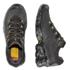 Un par de zapatillas de montaña La Sportiva Ultra Raptor II Leather GTX negras con suelas resistentes y detalles en amarillo. Una de las zapatillas se ve de lado y la otra de arriba hacia abajo, mostrando el diseño con cordones y la plantilla con la marca. Ideales para cualquier aventura en la montaña.
