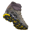 La bota de trekking resistente La Sportiva Ultra Raptor II Mid Leather GTX en gris y morado oscuro presenta un diseño de tobillo alto con una suela texturizada duradera con detalles en amarillo. La marca "La Sportiva" se destaca de manera destacada en el costado.