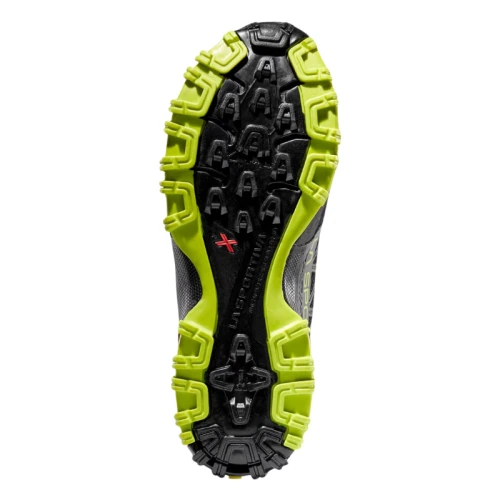 La imagen muestra la suela de una zapatilla para correr en montaña La Sportiva Bushido II, con una banda de rodadura negra y verde brillante con diversas formas de tacos para un mejor agarre y un logotipo central.
