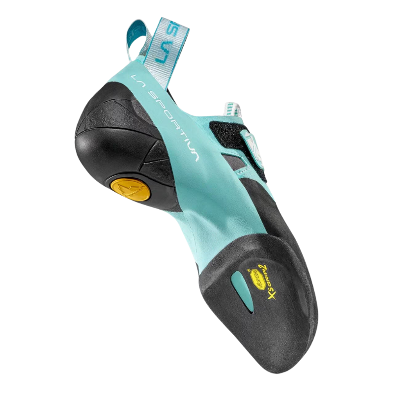 El calzado de escalada La Sportiva Skwama Vegan Mujer en turquesa y negro tiene una correa de velcro, una puntera redondeada reforzada y una suela con el logotipo Vibram XS Grip 2 en amarillo para escaladas de precisión. La marca "La Sportiva" se muestra de forma destacada en el lateral.