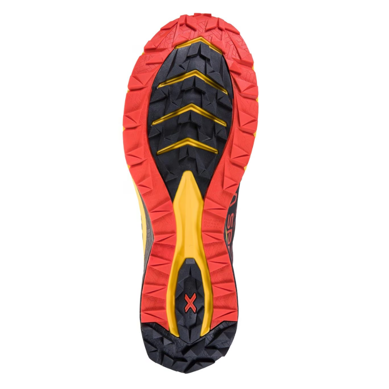 La imagen muestra la suela de la zapatilla para correr de montaña La Sportiva Jackal, con una banda de rodadura resistente en rojo, negro y amarillo para una excelente tracción y durabilidad.