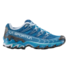 La zapatilla de montaña para correr La Sportiva Ultra Raptor II Mujer en azul y blanco presenta un diseño geométrico texturizado, suela resistente para tracción en aventuras al aire libre y muestra de manera destacada el nombre de la marca La Sportiva en el costado.