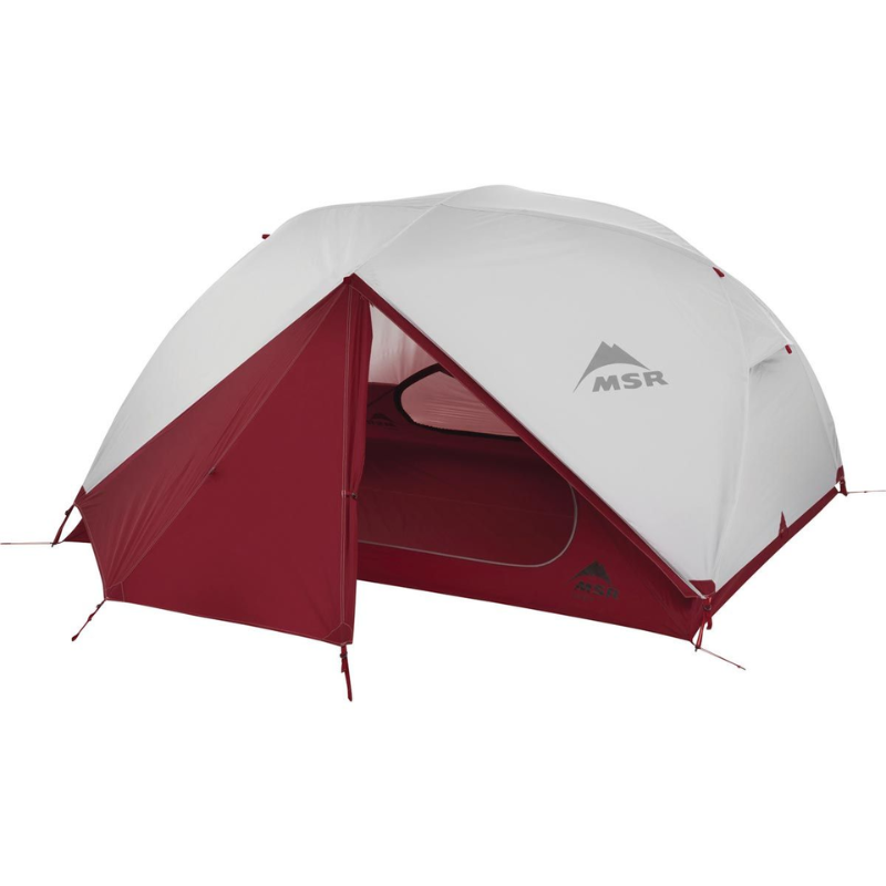 La Carpa MSR Elixir 2 (copia), una carpa con forma de cúpula de color rojo y blanco, cuenta con una entrada abierta que muestra el logotipo "MSR". Con su espacioso interior y su diseño resistente sobre un fondo blanco liso, es perfecta para aventuras de campamento al aire libre.
