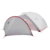 La Carpa MSR Remote 2 (copia) es una carpa para exteriores gris y roja con dos secciones y un diseño arqueado, que cuenta con un toldo exterior con el logotipo de MSR para protección contra la intemperie, lo que la hace ideal para acampar.