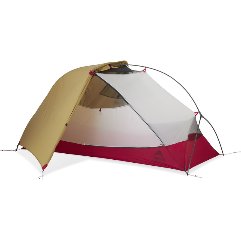 La Carpa MSR Elixir 3 (copia) es una tienda de campaña que cuenta con un toldo beige, un interior rojo y blanco, postes livianos y un frente de malla para ventilación. Está montada sobre un fondo blanco prístino, lo que ofrece comodidad y estilo para tus aventuras.