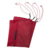 El Carpa MSR Remote 2 incluye una bolsa de transporte roja doblada con cuatro cordones trenzados rojos y blancos, acentuados por dos pestañas grises cerca de sus extremos.