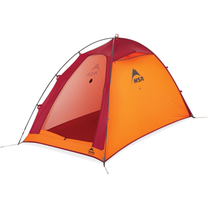 La carpa MSR Hubba Hubba 2 (copia) presenta una forma de cúpula de color rojo y naranja brillante con una solapa frontal parcialmente abierta, ideal para dos personas. La carpa, que presenta el logotipo de MSR, se exhibe sobre un fondo blanco prístino.