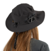 Una persona con cabello largo y castaño mira hacia otro lado sobre un fondo blanco y lleva un sombrero negro Atakama Outdoor Lircay. El sombrero tiene ala ancha, correa para la barbilla y detalle de hebilla en el costado.