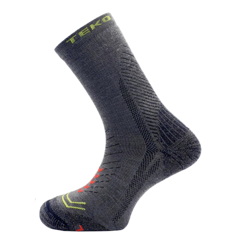 El Calcetín Teko EcoHike Discovery Light Half Cushion 2.0 es un elegante calcetín gris oscuro que presenta patrones intrincados, texto amarillo en el tobillo y acentos vibrantes en rojo y amarillo en la puntera y el costado, que se muestran sobre un fondo blanco, ideal para espíritus aventureros.