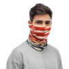 Una persona lleva un suéter gris claro y la Bandana Buff Original EcoStretch Burst Of Light, una polaina para el cuello multicolor con rayas rojas y beige y detalles en azul. Cubre la mitad inferior de la cara y ofrece un estilo versátil similar al patrón de Saltire.