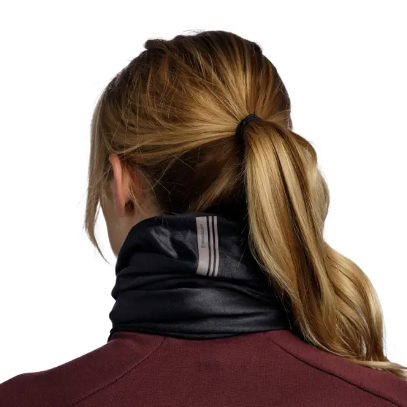 Una persona con cabello castaño claro recogido en una cola de caballo lleva una bandana Buff ThermoNet® Pow Lixot Green, con dos rayas reflectantes en la espalda. Se la ve de espaldas con una camiseta granate sobre un fondo blanco.