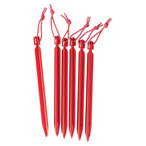 Seis Estacas para Carpa MSR Groundhog en color rojo con extremos puntiagudos y cordones rojos unidos, ordenadas cuidadosamente en fila sobre un fondo blanco.