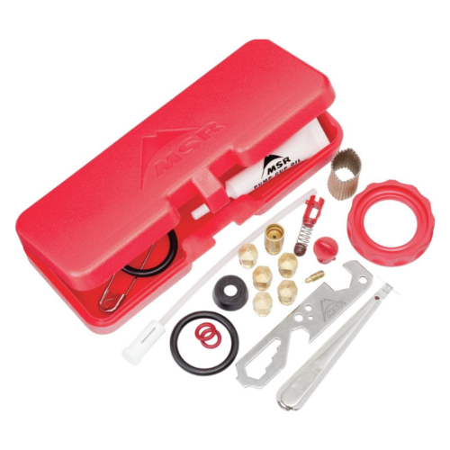 El kit de repuesto MSR Expedition Service incluye un estuche de plástico rojo con herramientas como una llave, juntas tóricas, una tapa roja, resortes y pequeñas piezas de metal. Los componentes están ordenados cuidadosamente junto al estuche abierto para resaltar sus intrincados detalles.