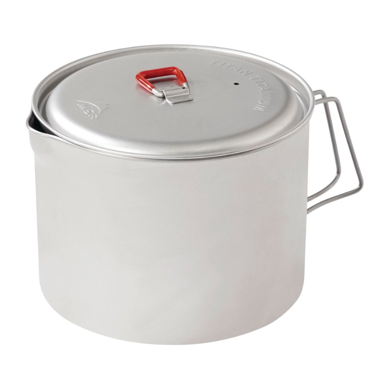 Una olla de camping de metal con tapa y asa roja, con asas de alambre plegables, similar a la Sartén Antiadherente MSR Quick Skillet (copia), perfecta para cocinar al aire libre.