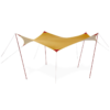 Una carpa con dosel de color amarillo y beige y postes rojos se encuentra junto a una botella de combustible MSR (copia). El dosel rectangular se eleva en el centro, sostenido por cuerdas delgadas, sobre un fondo blanco liso.